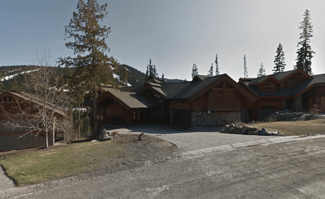 A Google Streetview screen capture showing a stone and brick home from the street. 