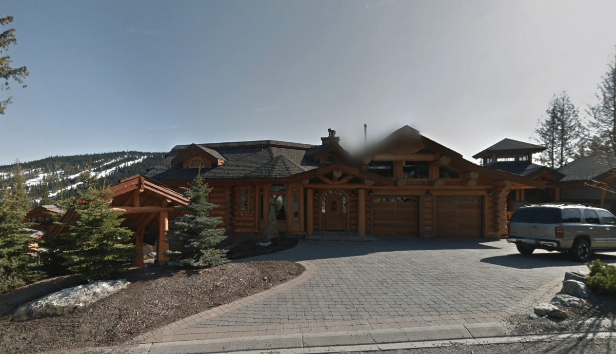 A Google Streetview screen capture showing a log home from the street. 