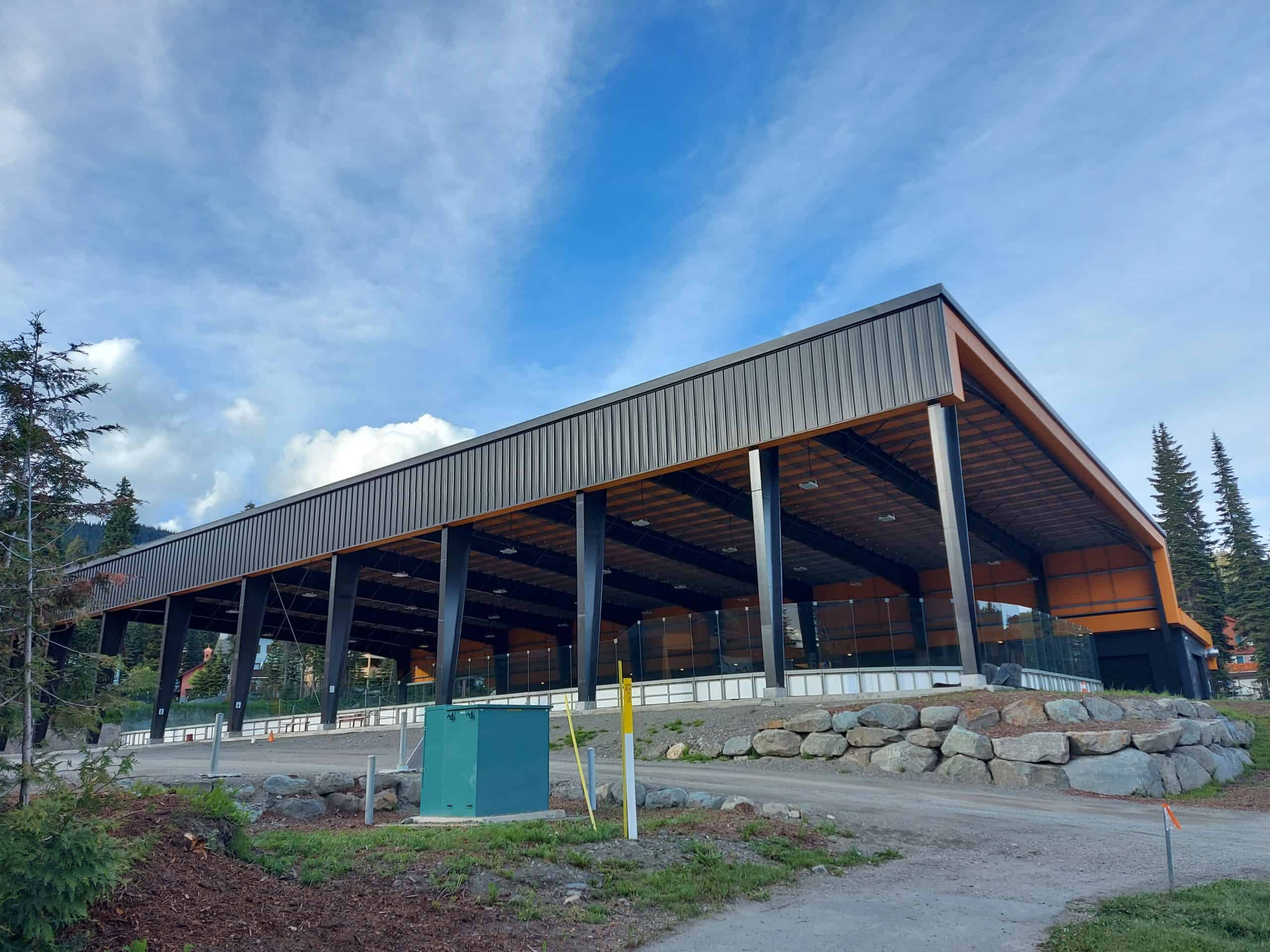 Sun Peaks arena has a covered roof and open walls. A blue sky with light clouds is in the bankground
