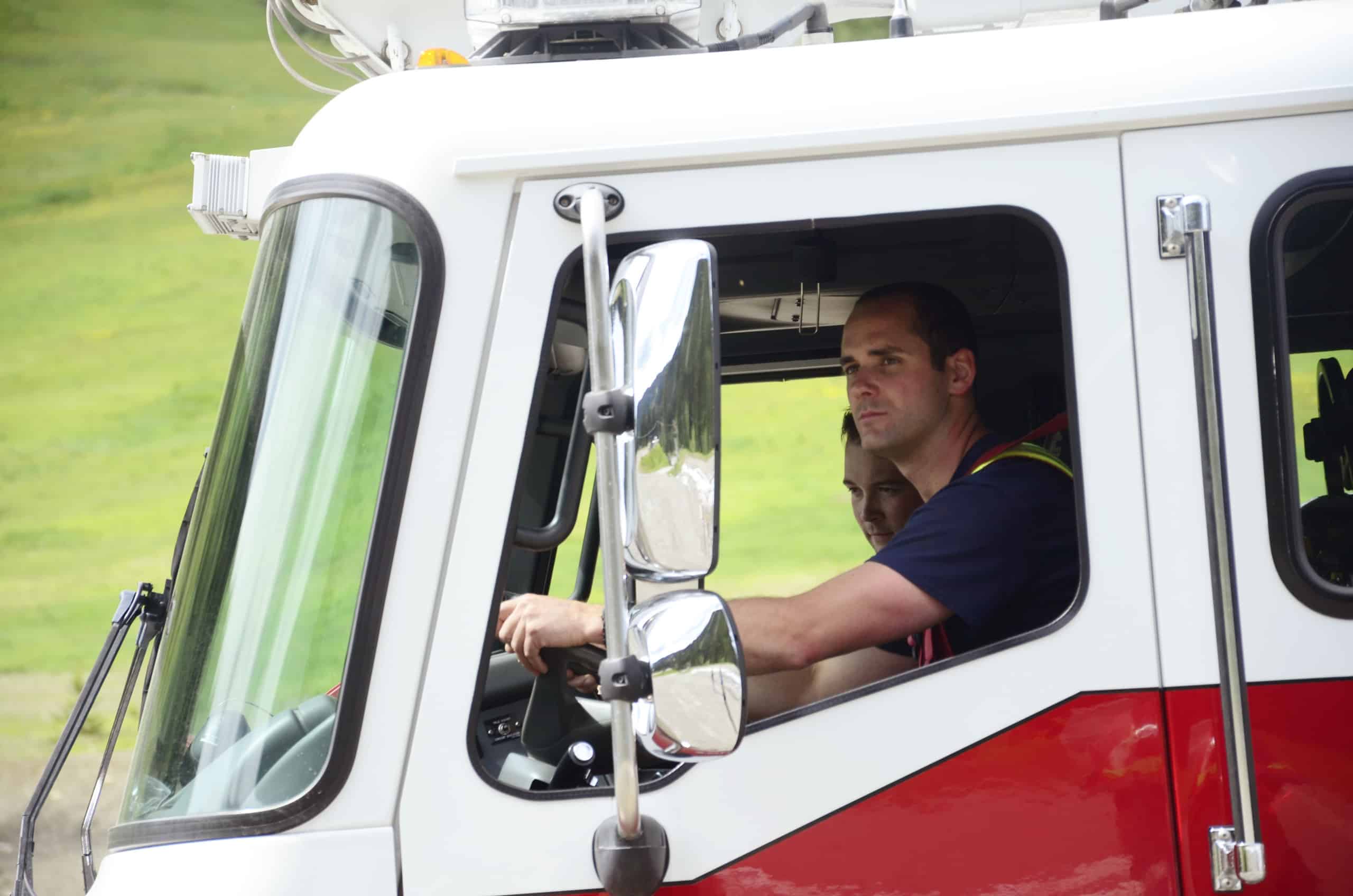 Kevan Ramsden drives the fire truck under the watchful eye of Joss Advocaat.