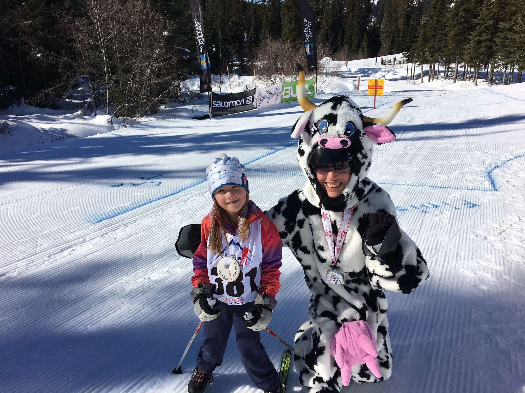 Big smiles: Maya Roberts poses with the Holy Cow mascot following her two kilometre ski. - Photo Submitted