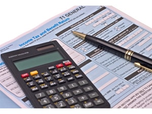 A calculator and a pen rest on the top of paper used for filing taxes.