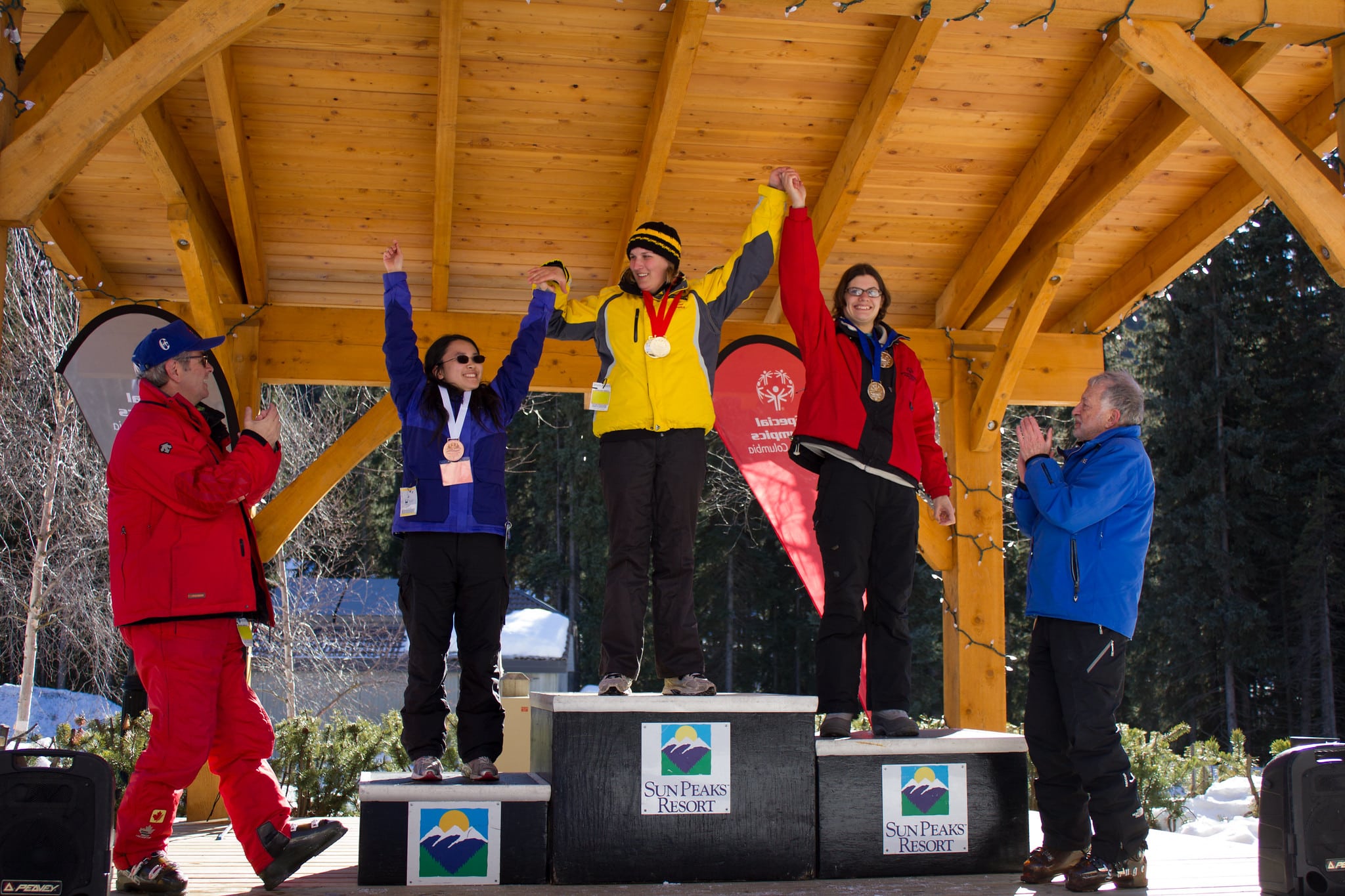 Athletes raise their hands on the podium at the 2015 Special Olympics winter games, held at Sun Peaks Resort.