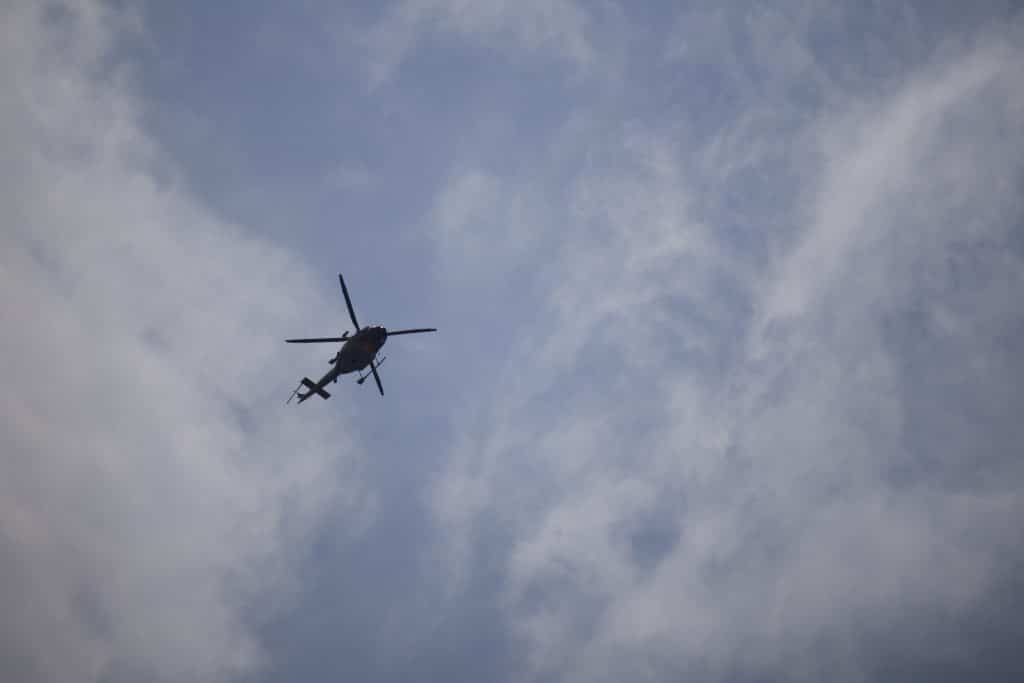 A helicopter flies in the sky above Sun Peaks, responding to reports of a wildfire in the area. 