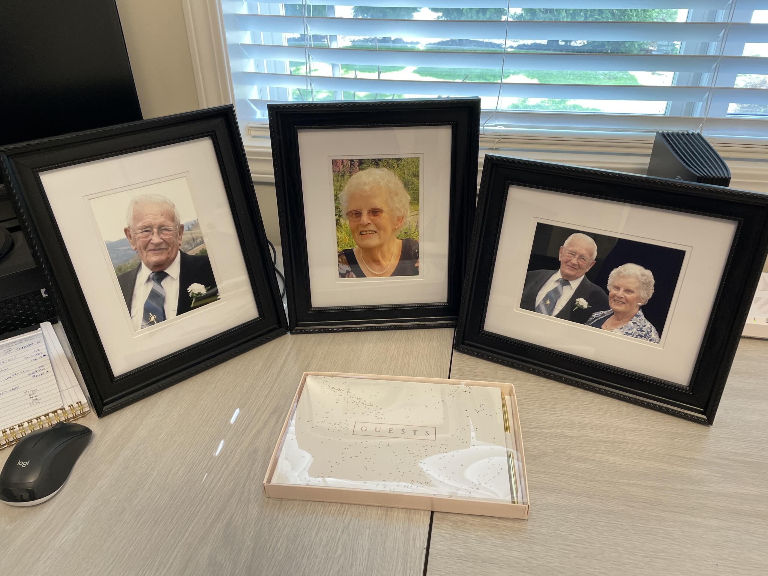 Photos of Robert and Rose White sit on a desk with a guest book in front the the picture frames. Whitecroft