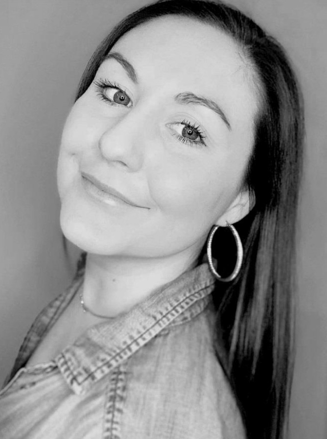 A black and white portrait of a woman with long brown.