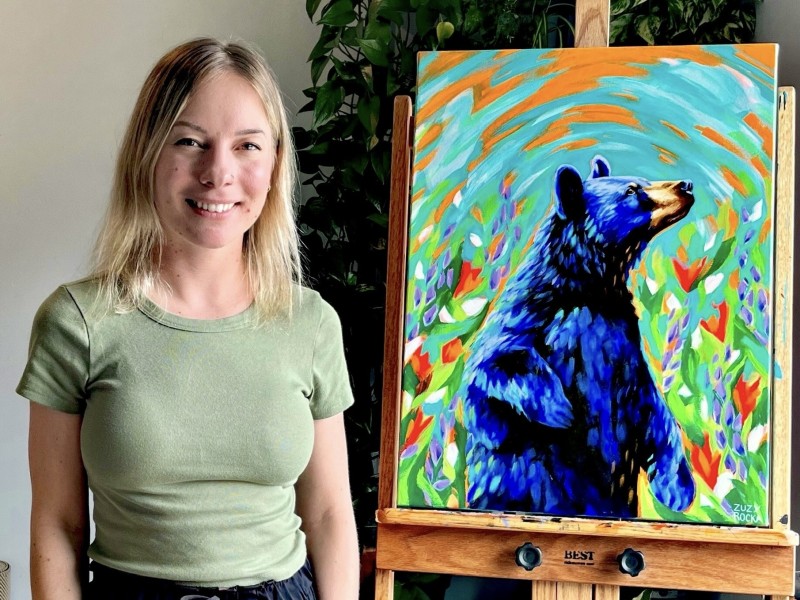 Zuzy Rocka in her studio with her painting Resplendent, a splash of colour in a bear design.
