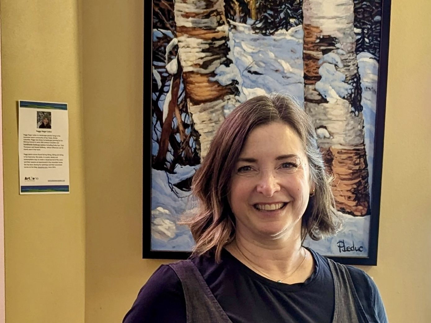 Peggy Heger LeDuc with her painting Early Snow in Whitecroft Meadow in Vertical Cafe.